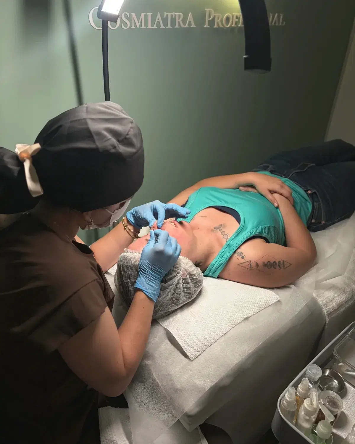 Cosmiatra realizando un tratamiento facial en la cabina verde salvia del estudio
